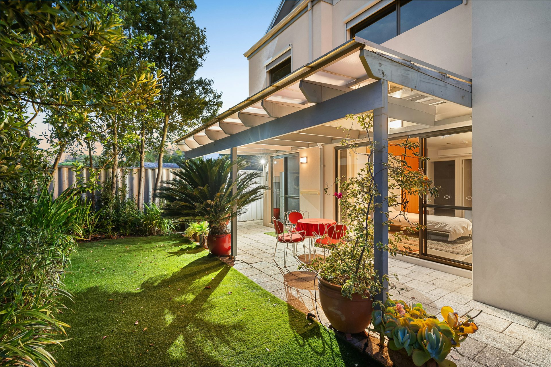 A backyard with a covered patio and a table and chairs